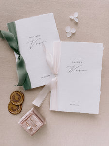 White handmade paper personalized vow books tied with olive green and antique white silk ribbons