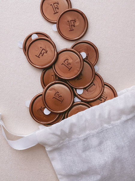 Single initial monogram wax seal stickers in copper color in linen bag
