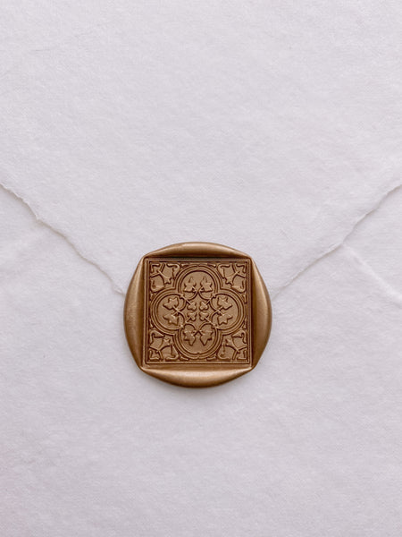Moroccan tile pattern square shaped wax seal in gold on white handmade paper envelope_closeup front angle