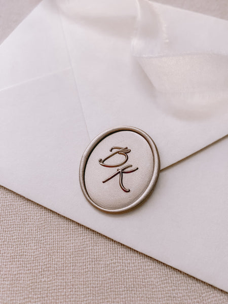 Calligraphy script monogram oval wax seal in color Mocha on paper envelope_side angle