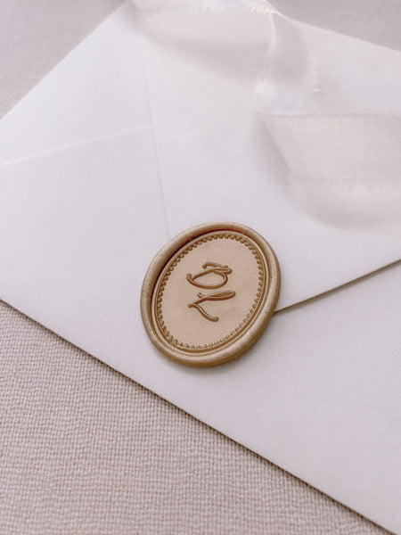 Border design oval monogram wax seal in light gold on paper envelope_side angle