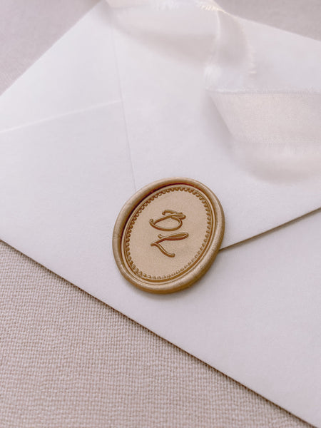 Calligraphy script monogram with border design oval wax seal in light gold on paper envelope_side angle