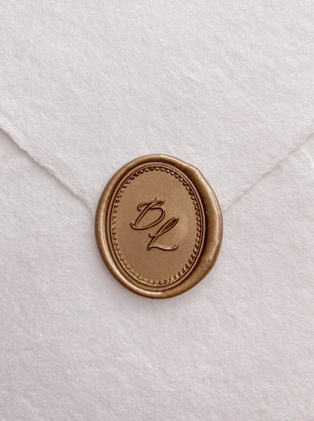 Calligraphy script monogram with border design oval wax seal in gold on handmade paper envelope_front angle