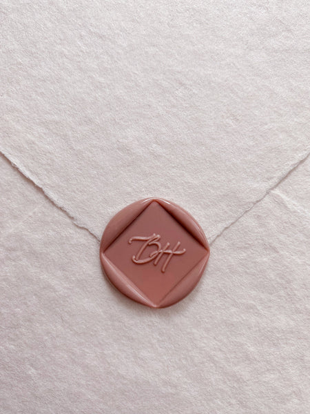 Calligraphy script monogram diamond shaped wax seal in dusty rose handmade paper envelope_front angle