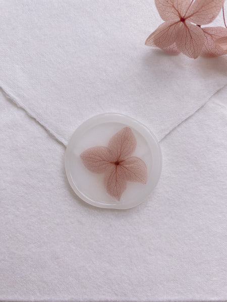 Pale mauve color dried hydrangea petal on clear color wax seal