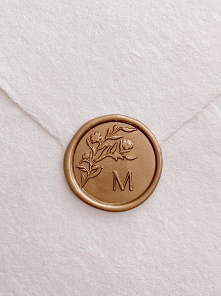 Floral silhouette single initial wax seal in gold on handmade paper envelope