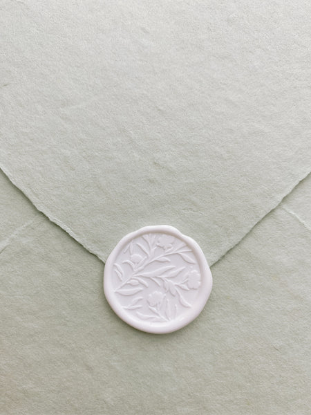 Floral silhouette wax seal in white on handmade paper envelope_front angle