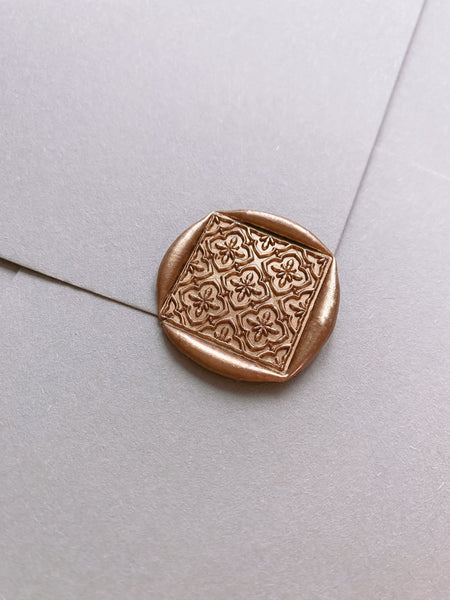 Moroccan tile pattern diamond shaped wax seal in gold on paper envelope_side angle