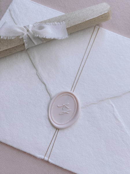 ivory nude colored oval monogram wax seal on handmade paper envelope_closeup side angle