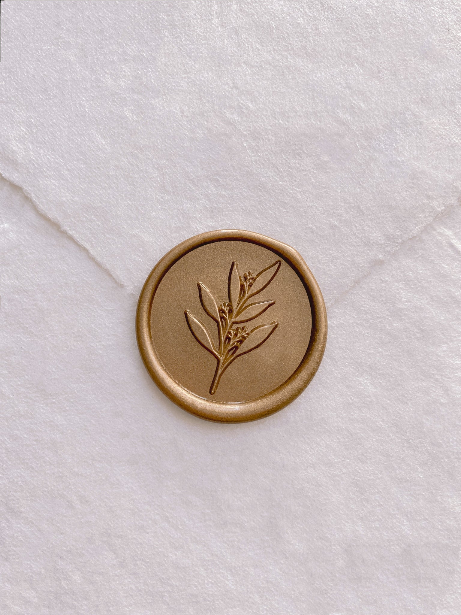 Leaf branch wax seal in gold on handmade paper envelope_front angle