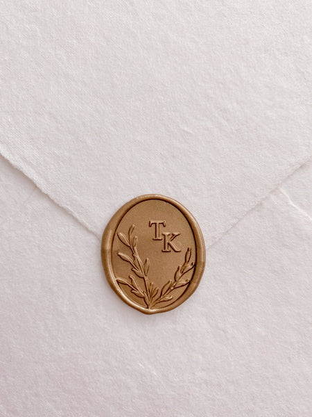 Oval leaf wreath design monogram wax seal in gold on handmade paper envelope_front angle