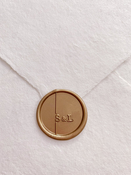 Modern monogram gold wax seal on handmade paper envelope