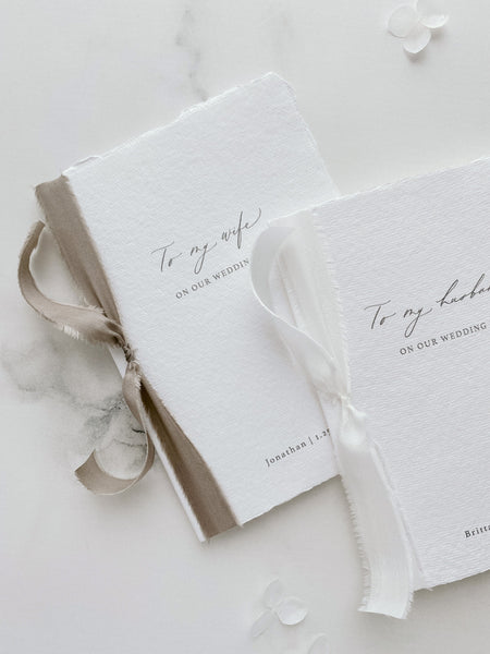 Set of 2 personalized Love Letter booklets tied in white and taupe colored silk ribbons_front angle close up