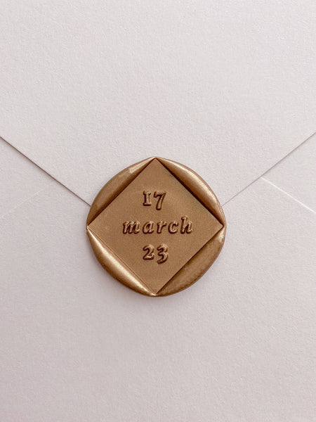 Personalized wedding date diamond shaped wax seal in gold_front angle