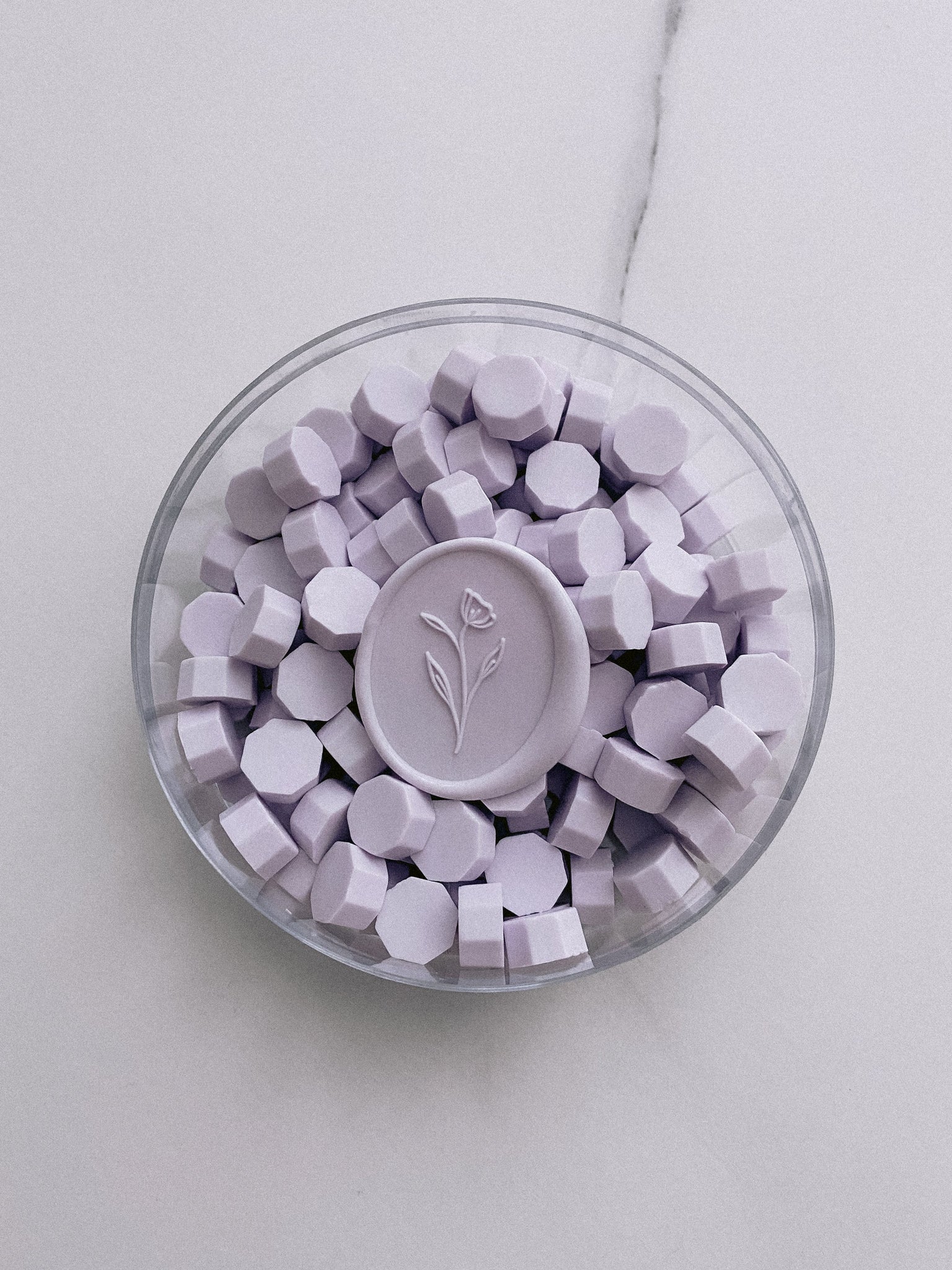 a box of light lilac color sealing wax beads with simple flower wax seal in light lilac