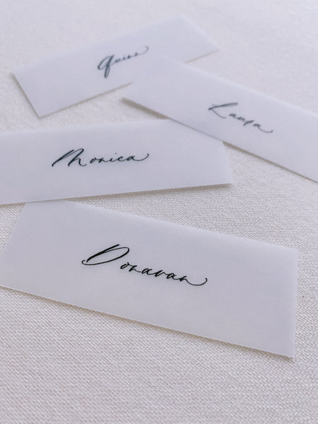 slim vellum place cards in hand lettered calligraphy in gold ink_closeup front angle