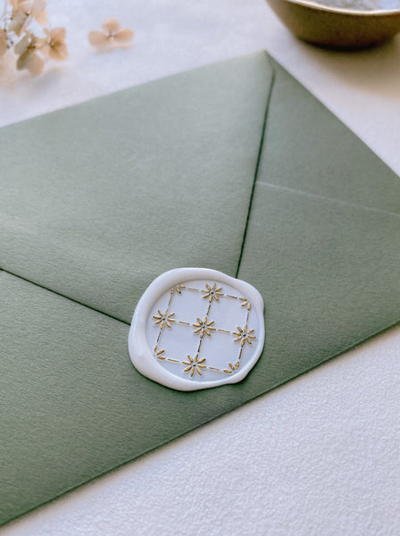 Daisy flower pattern wax seal in white with gold embellished flowers on green envelope_side angle