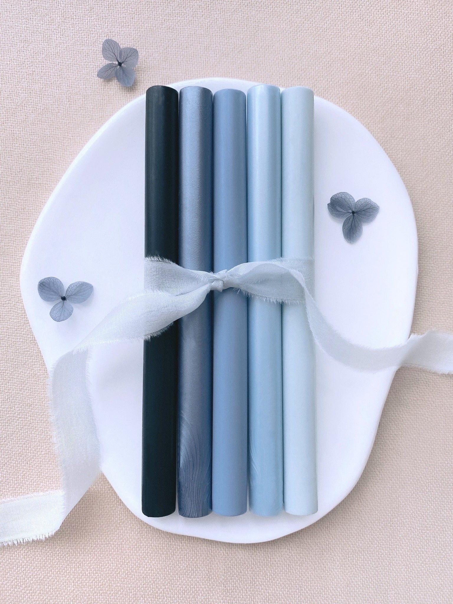 a set of 5 blue tones sealing wax sticks in deep blue, slate blue, dusty blue, light blue, sky colors