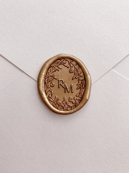 Oval floral crown monogram wax seal in classic gold on envelope