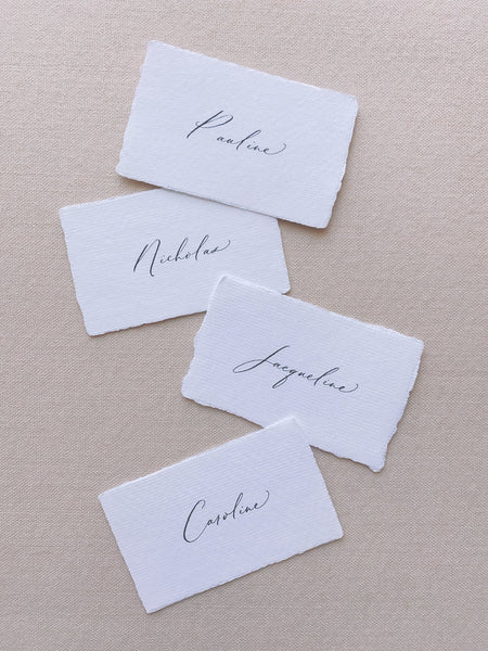 handmade paper place cards in white color hand lettered in modern calligraphy in black ink_front angle
